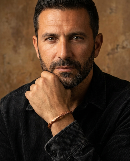 Retrato do modelo com a mao no queixo mostrando o bracelete de cobre