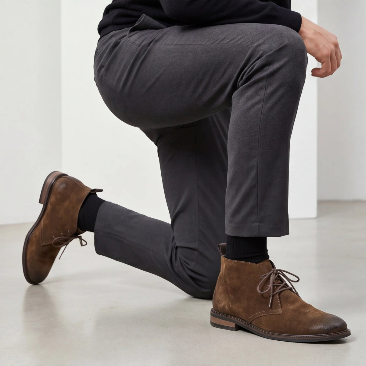 Bota Pampa Camurça com calça cinza de alfaiataria, homem ajoelhado